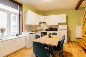 a kitchen with a wooden table and chairs at Maison du Doudou centre ville Mons in Mons