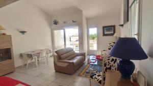 a living room with a couch and a table at La Vague de Pontaillac 55m2 in Royan