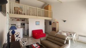 a living room with a couch and a red chair at La Vague de Pontaillac 55m2 in Royan