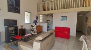 a living room with a couch and a red chair at La Vague de Pontaillac 55m2 in Royan