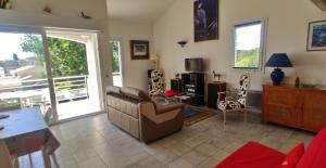 a living room with a couch and a table at La Vague de Pontaillac 55m2 in Royan +26 photos