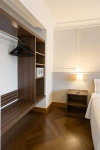 a bedroom with a bed and a nightstand next to a table at Suíte Confort - Resort no Coração de Gramado in Gramado