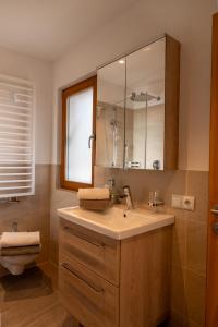 a bathroom with a sink and a toilet and a mirror at Schweinsteghof Urlaub auf dem Bauernhof in Sarntal