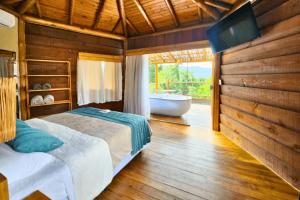 a bedroom with a bed and a tub and a television at Tahaa Pousada Boutique in Ilhabela +37 photos