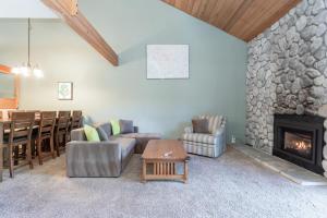 a living room with a stone fireplace and a table at Snowcreek IV 588 in Mammoth Lakes