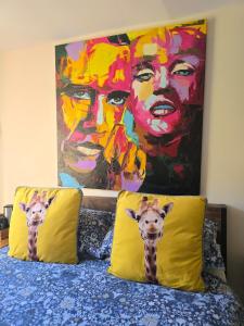 two giraffe pillows on a bed with a painting at Family Room in Llanidloes