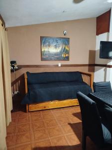 1 dormitorio con sofá azul y una pintura en la pared en Chalet " La Maruca ", en Villa Carlos Paz