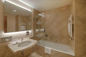 a bathroom with a sink and a tub and a mirror at NH Ravenna in Ravenna +51 photos