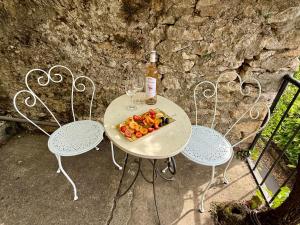 a table with a plate of fruit and a bottle of wine at Le Coin Tranquille in La Roque-Gageac +43 photos