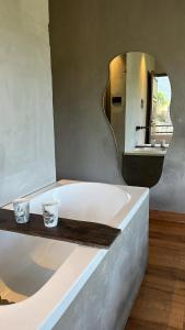 a bathroom with a bath tub with a mirror at Ecstacy bathtub rooms and cafe - Homestay in mukteshwar in Mukteswar