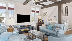 ein Wohnzimmer mit blauen Möbeln und einem TV in der Unterkunft Serene 30A Getaway Near Beach w Pool Firepit Porch Sea Salt by AvantStay in Grosh