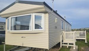 een tiny house met een raam en een stoel bij South Breeze Caravans Rio in Camber