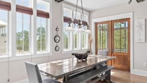 ein Esszimmer mit Tisch und Stühlen und Fenstern in der Unterkunft Serene 30A Getaway Near Beach w Pool Firepit Porch Sea Salt by AvantStay in Grosh