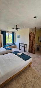 a large bedroom with two beds and a window at Villas Coral in Dzidzantún