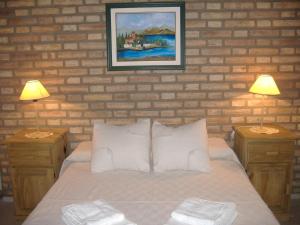 a bedroom with a bed with two nightstands and two lamps at Cabañas Acacias in San Antonio de Arredondo +16 photos