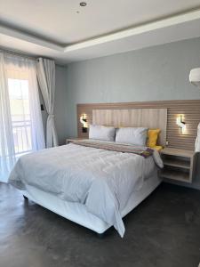 Una cama blanca grande en un dormitorio con ventana. en Fourteen38 Mews Guesthouse, en Dwarsloop