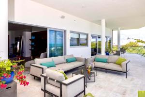 a living room with couches and tables and windows at Villa Skyline with stunning Ocean View in Turtle Cove +56 photos