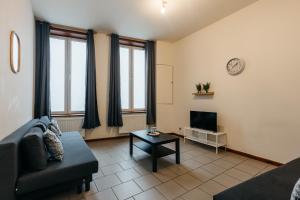 un salon avec un canapé et une télévision dans l'établissement Maison du Beffroi de Mons centre ville, à Mons