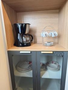 a cupboard with plates and a blender on it at Apartment 402 withoeft in Pomerode +6 photos