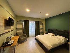 a bedroom with a bed and a table and a chair at TUNA OTEL in Gelibolu +8 photos