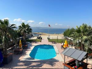a swimming pool with tables and chairs and a beach at TUNA OTEL in Gelibolu