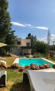 a swimming pool in front of a house at Altos del Oeste in Villa Carlos Paz