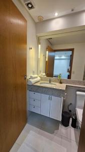 ein Badezimmer mit Waschbecken und großem Spiegel in der Unterkunft Flat Valedo in Palmas + 7 Fotos