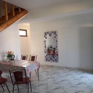 a dining room with a table and chairs and a mirror at Hotel Javlonbek 1 in Samarkand