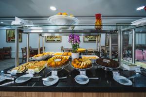 クリチバにあるHotel Golden Park Curitiba By Nacional Innのテーブルの上にさまざまな種類の食べ物が並んだビュッフェ
