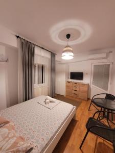 a bedroom with a bed and a table and a tv at Vila Didi, Mangalia in Mangalia