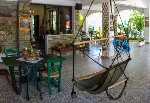 a room with a table and chairs and a swing at Dionisos Palms Apartments in Paralia Dionysiou