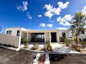 a white house with a lot of windows at Villa Jupiter with Private Pool Oceanfront in Turtle Cove