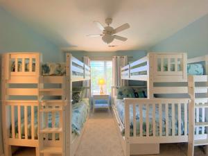 une chambre avec deux lits superposés et un ventilateur de plafond dans l'établissement Lookout Point, à Edisto Island