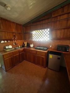 una cucina con armadi in legno, lavandino e finestra di Ballena Oasis Homes & Glamping a Uvita Altre 52 foto
