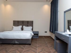 Un dormitorio con una cama, un tocador y un espejo. en رايز العارض للشقق المخدومة, en Riad