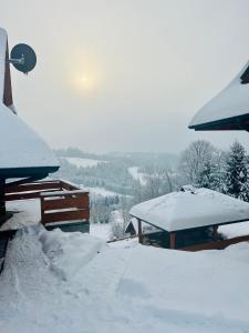 a snow covered roof of a house with snow at Osada Małysze in Jaworzynka