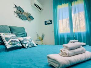 a room with a bed with towels on it at BluSunset Home Capaci in Capaci