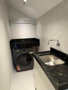 a kitchen with a sink and a washing machine at Apartment 403 withoeft in Pomerode +11 photos