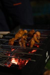 a bunch of food is cooking on a grill at Ecstacy bathtub rooms and cafe - Homestay in mukteshwar in Mukteswar