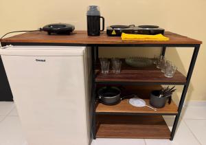 a shelf with a table on top of a refrigerator at Figueiredo Hosp 3 in Presidente Figueiredo