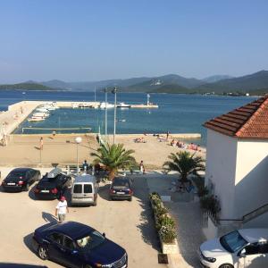 a group of cars parked in a parking lot next to a beach at Apartments Neda in Drače