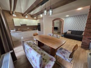 eine Küche und ein Wohnzimmer mit einem Holztisch und Stühlen in der Unterkunft Penzion Bedřiška Kraslice in Kraslice + 9 Fotos