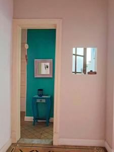 a hallway with a blue table and a window at Habitación privada, solo Damas "Alma de mujer" in Buenos Aires
