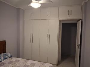 1 dormitorio con armarios blancos y 1 cama en Quarto em frente a praia do Boqueirão, en Santos
