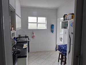 una cocina con estufa y refrigerador en Quarto em frente a praia do Boqueirão, en Santos