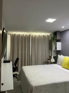 Un dormitorio con una gran cama blanca y un escritorio. en APART HOTEL MANAÍRA PALACE, en João Pessoa 20 fotos más