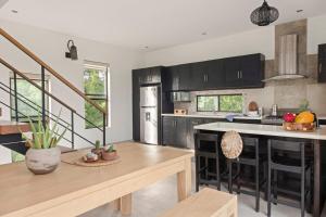 a kitchen with black cabinets and a kitchen island at Vista Popoyo 3BR Coastal Retreat with Surf & Mangrove Views in Popoyo