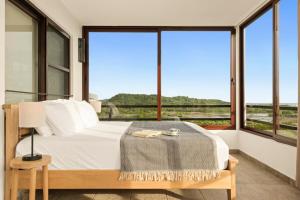 a bedroom with a bed and large windows at Vista Popoyo 3BR Coastal Retreat with Surf & Mangrove Views in Popoyo
