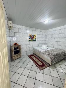 ein Schlafzimmer mit einem Bett und einer gefliesten Wand in der Unterkunft Refúgio das Ondas - Casa a 1 minuto da praia in Palhoça