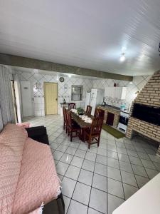 eine Küche und ein Esszimmer mit Tisch und Stühlen in der Unterkunft Refúgio das Ondas - Casa a 1 minuto da praia in Palhoça